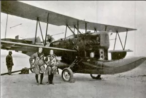 Captain Woolsey on the left and Lt. Benton on the right standing in front of their airplane the Detroit